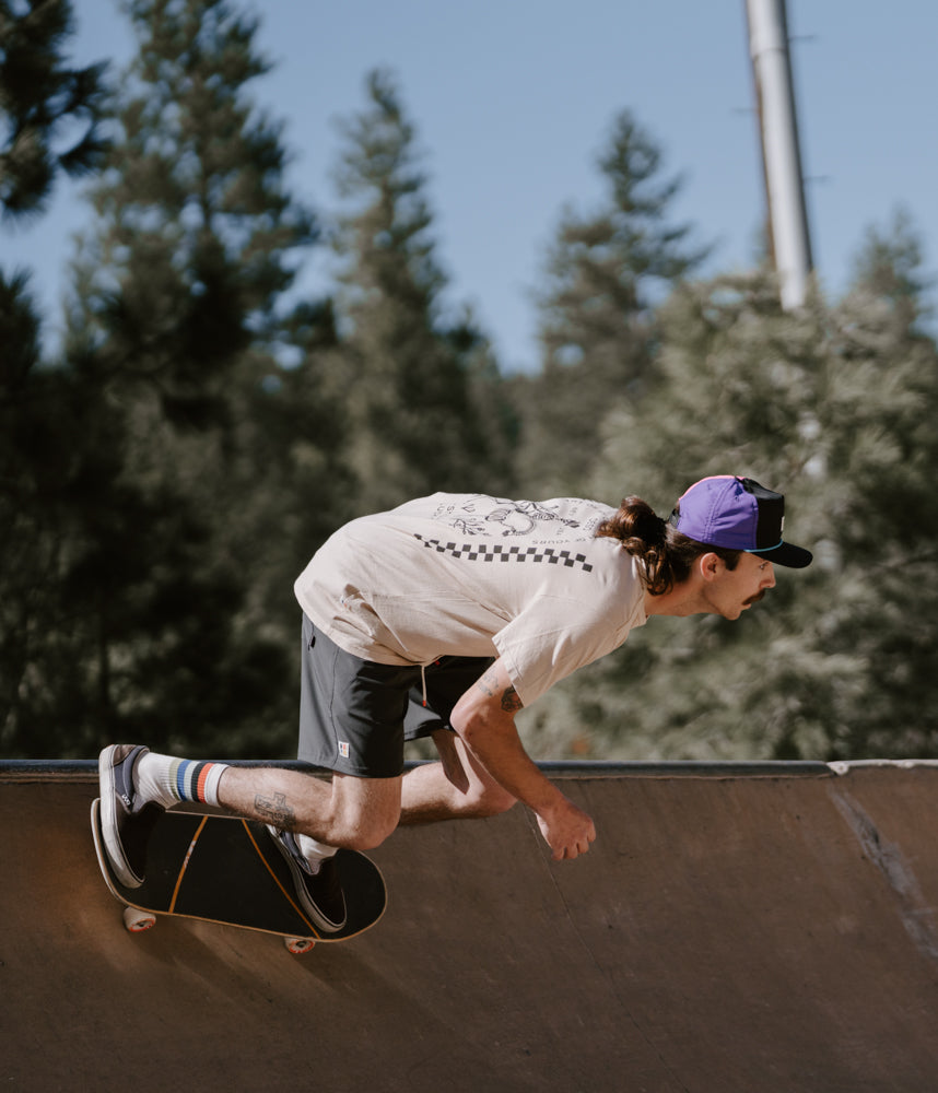 A man on a skateboard wearing Boca Board Shorts in deep forest color by Deso Supply Co.