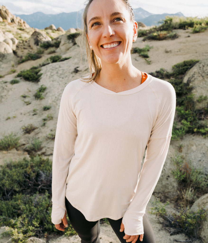 A woman outdoors wearing Shirley Long Sleeve in beige color by Deso Supply Co.