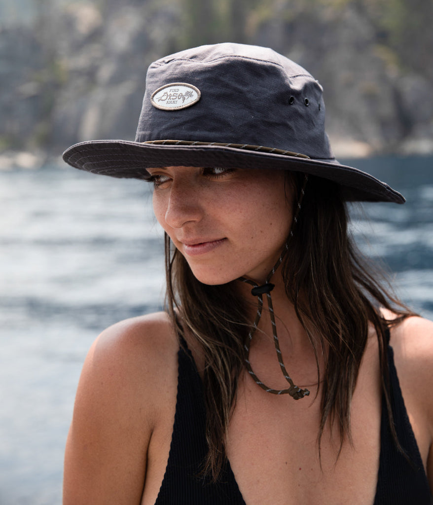 A woman wearing find away bucket cap in charcoal color by Deso Supply Co. 2
