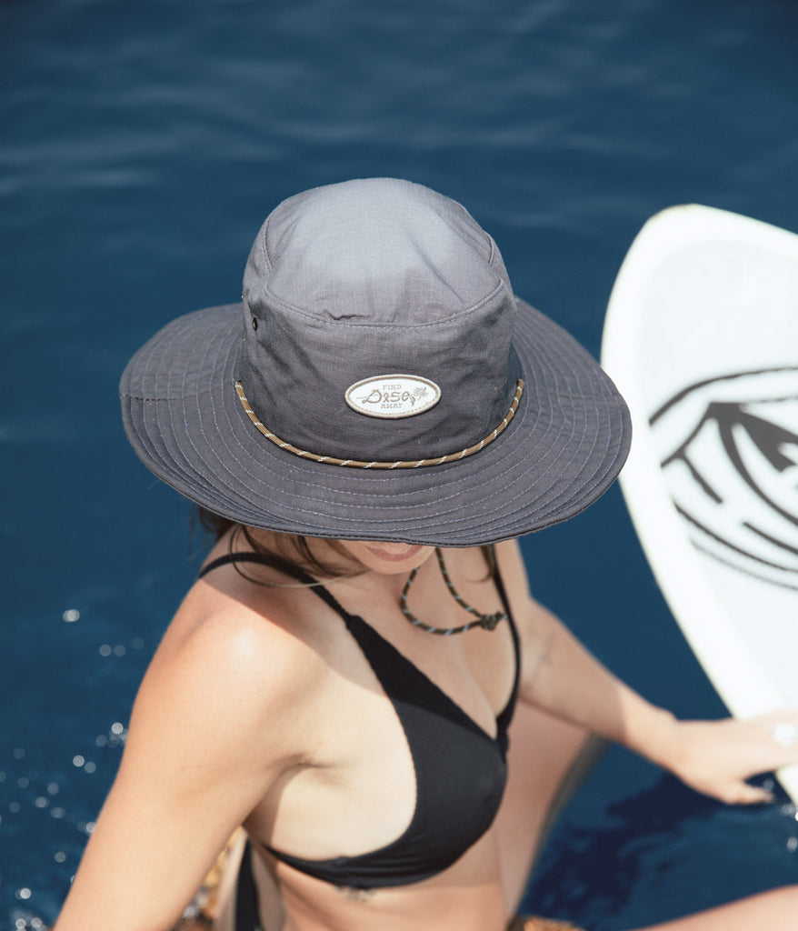 A woman wearing find away bucket cap in charcoal color by Deso Supply Co.