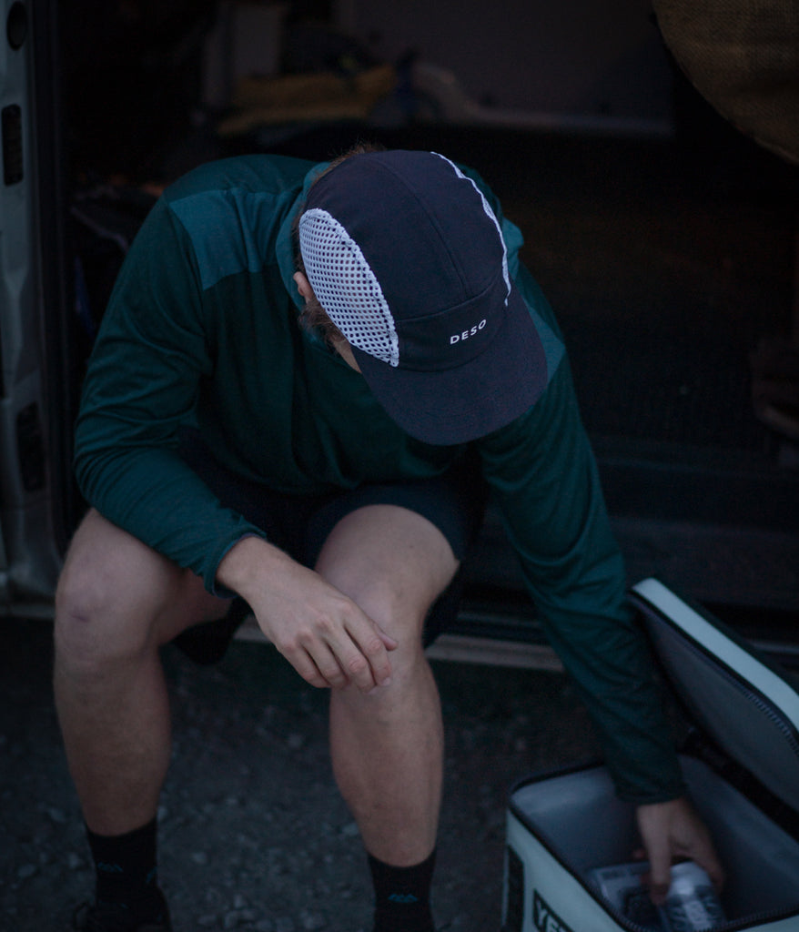 A man wearing a Jogger Camper Running Cap in a orion blue color by Deso Supply Co.