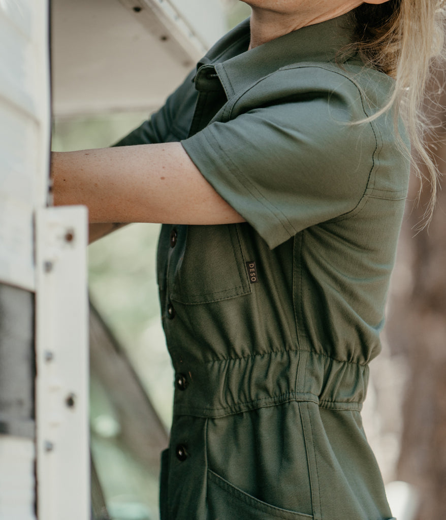 A woman wearing Homewood Coveralls in dark sage color by Deso Supply Co. 3