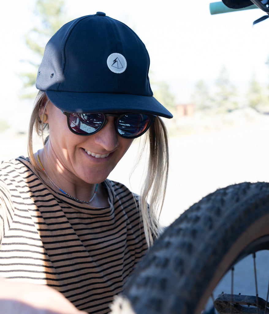 A woman wearing Hatchet 6 Panel Cap in midnight blue by Deso Supply Co.