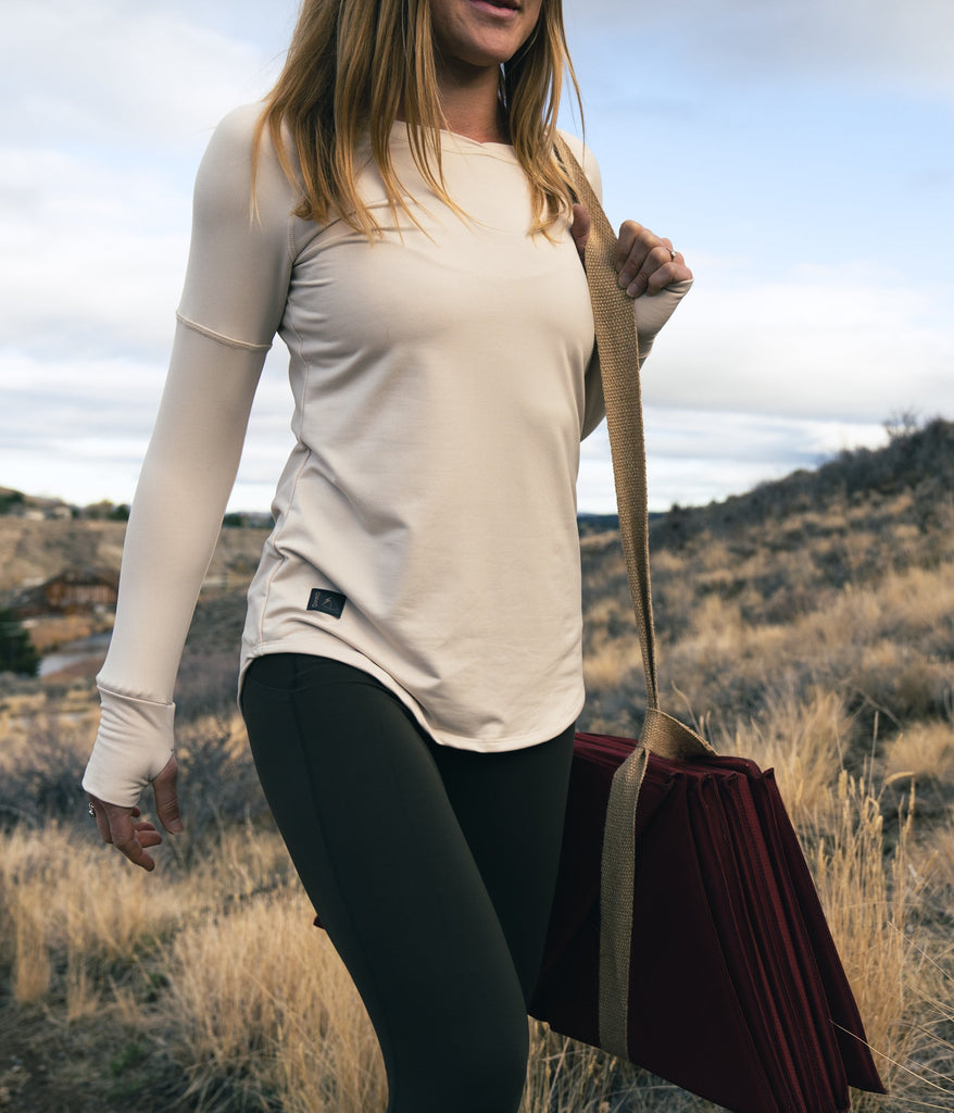 A woman outdoors wearing the Maggie Long sleeve in white sand color by Deso Supply Co.