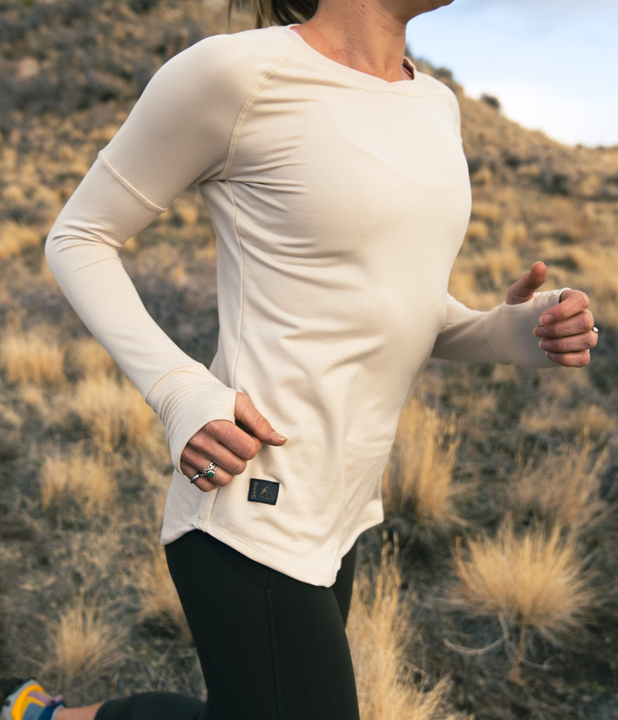 A close-up of a woman wearing Maggie Long sleeve in white sand color by Deso Supply Co.
