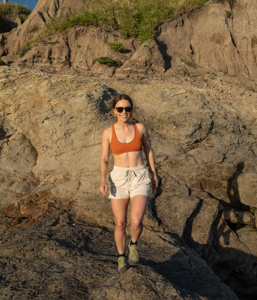 A woman outdoors wearing the Madora Short in white sand color by Deso Supply Co.