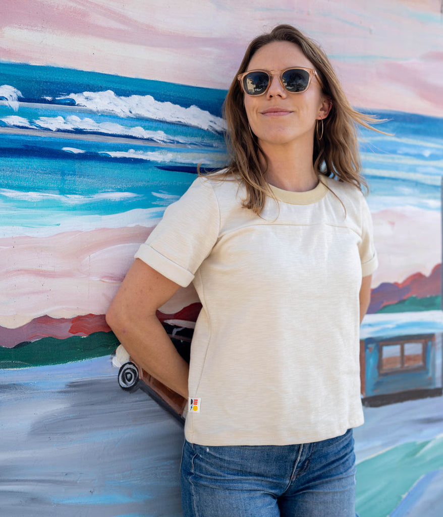 A woman wearing sunglasses and Kalmia Oversized Baggy Tee in sage color