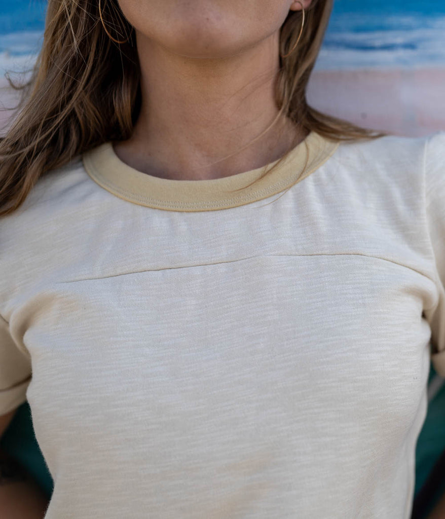 A close-up of a woman wearing the Kalmia Oversized Baggy Tee in sage color by Deso Supply Co. 1