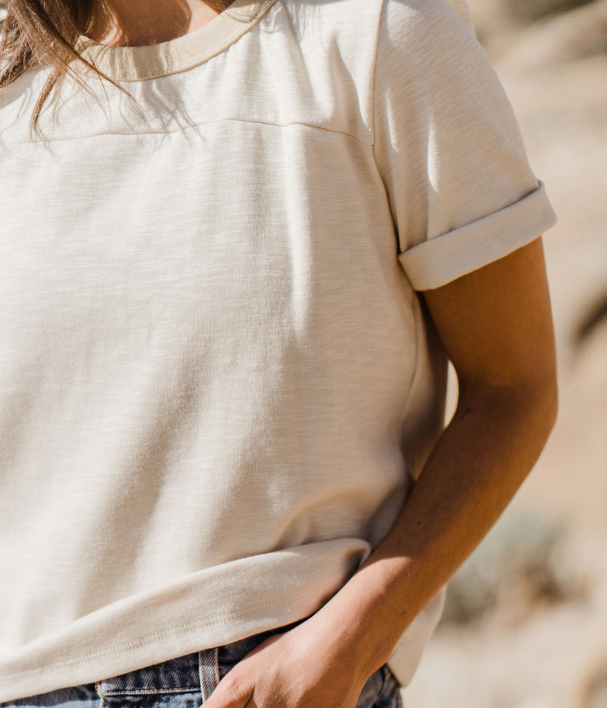  A close-up of a woman wearing the Kalmia Oversized Baggy Tee in sage color by Deso Supply Co.