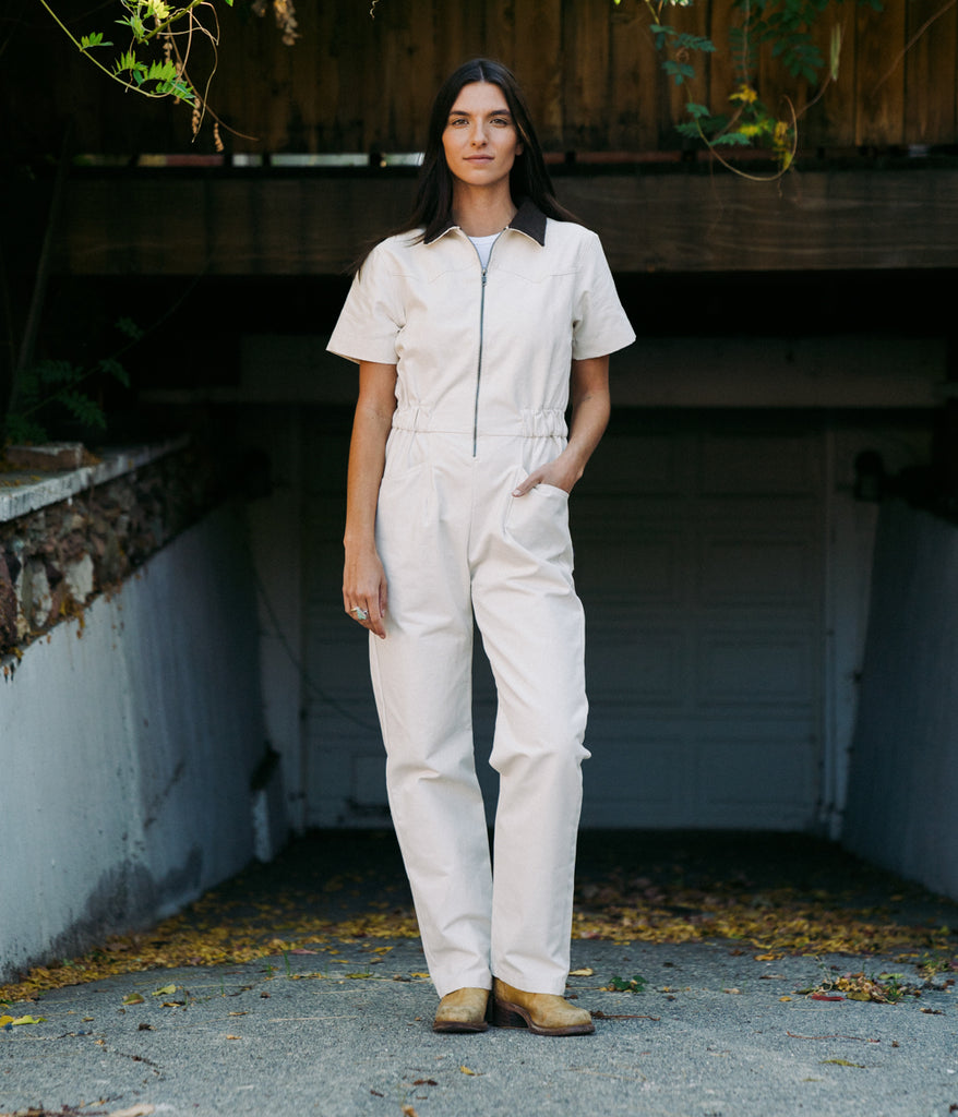 A woman wearing a bodie coverall in natural color by Deso Supply Co. 2
