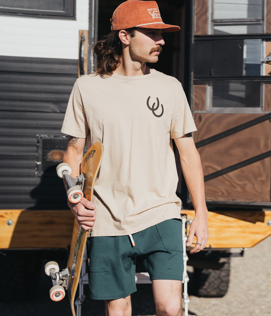 A man wearing the Still Lucky Tee in bone variant by Deso Supply Co.