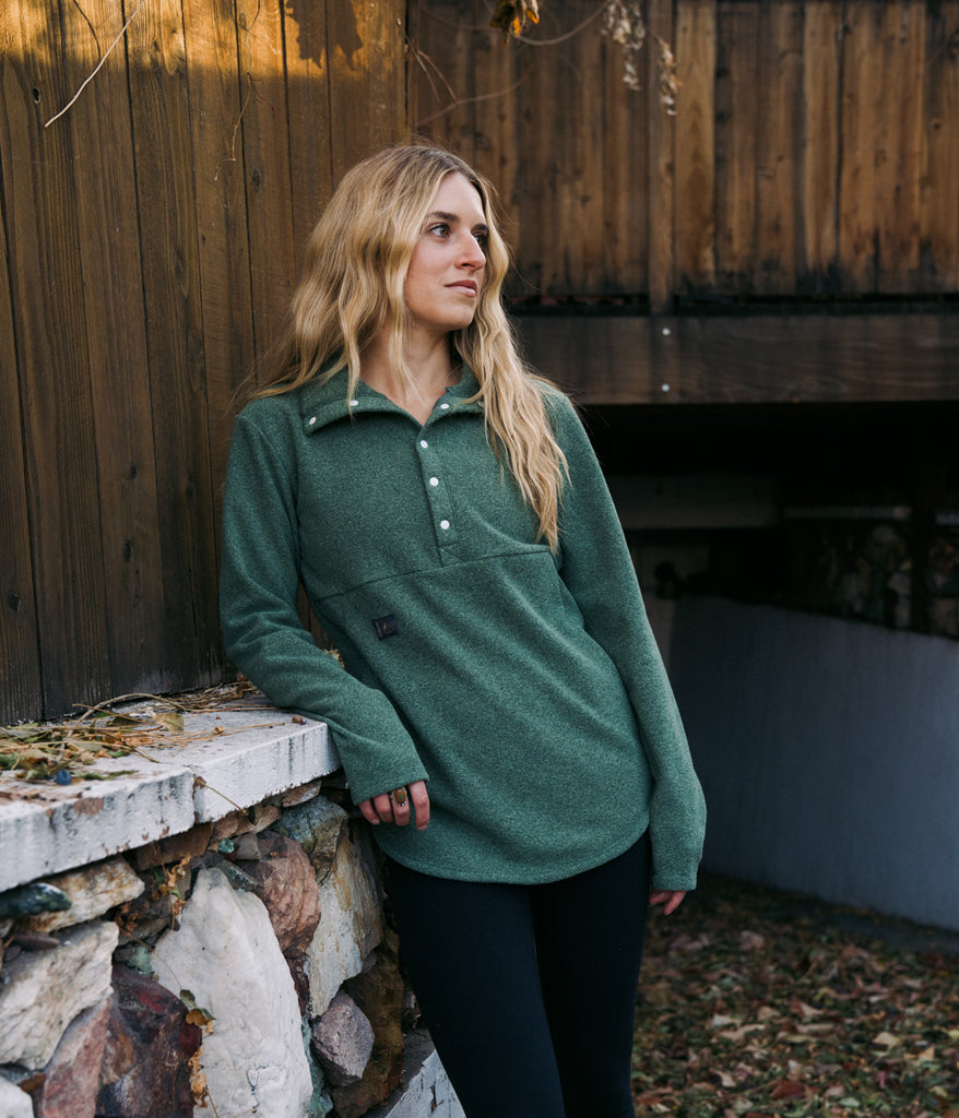 A woman wearing Genevieve Snap Pullover 6s in loden color by Deso Supply Co.