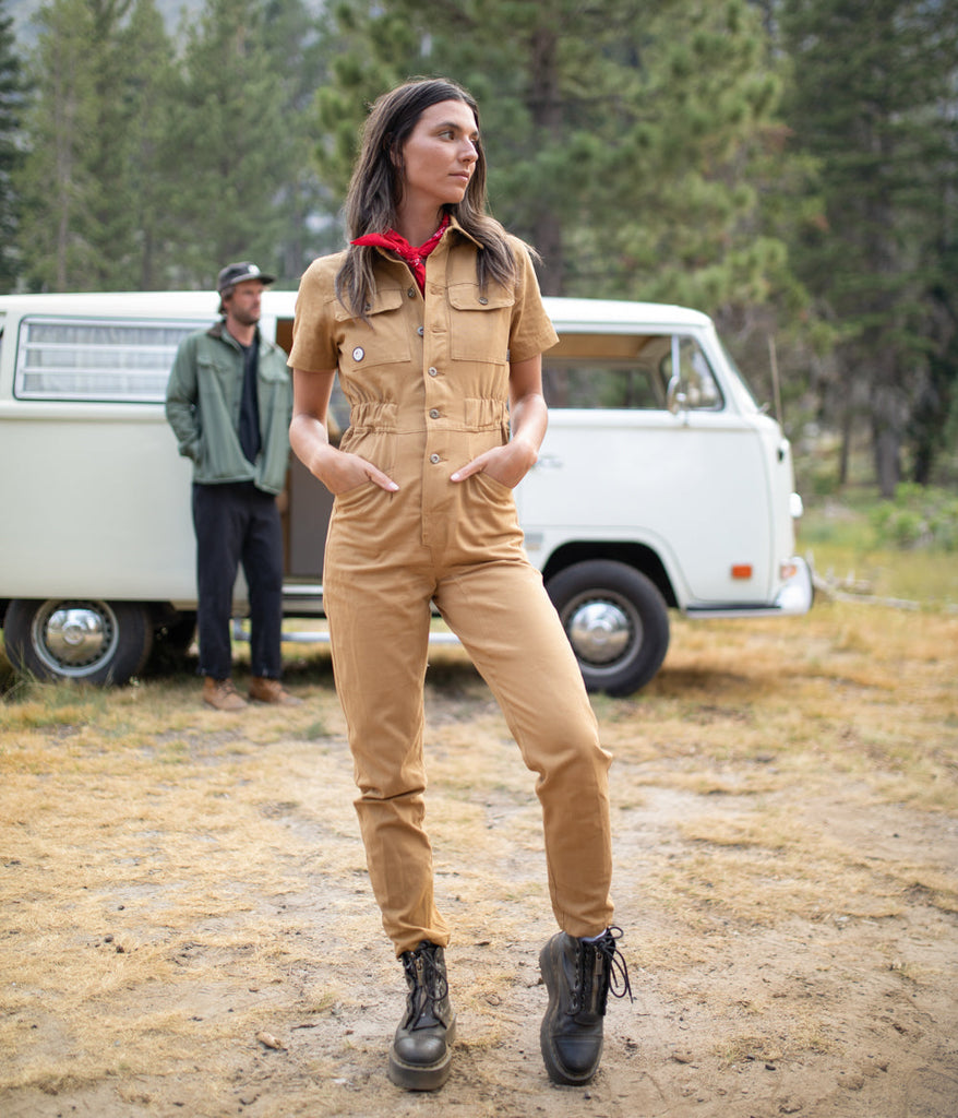 A woman wearing Homewood Coveralls in burlywood color by Deso Supply Co.