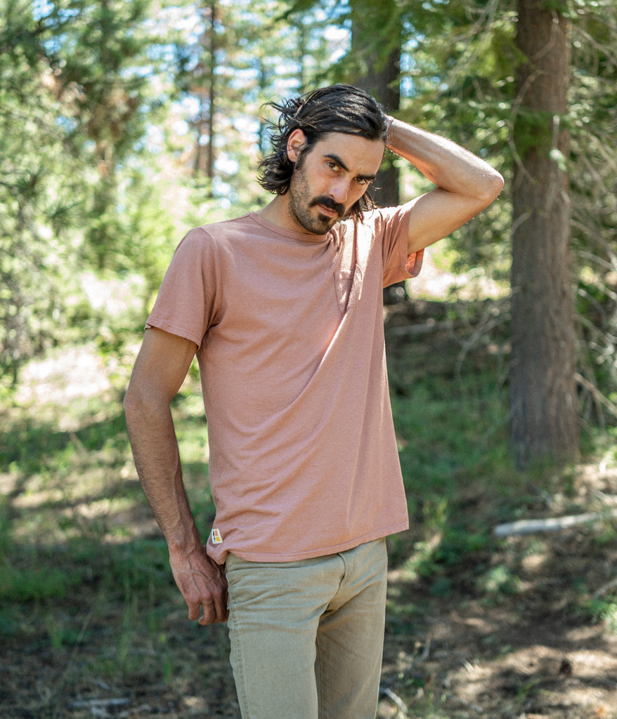 A man wearing a Men's Primary Pocket Tee in lavender color by Deso Supply Co. 1
