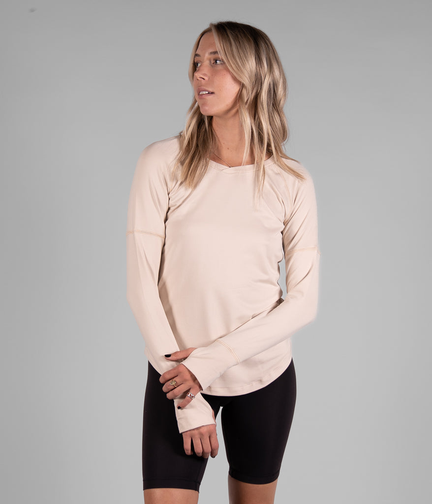 A woman wearing Maggie Long sleeve in white sand color by Deso Supply Co. 1