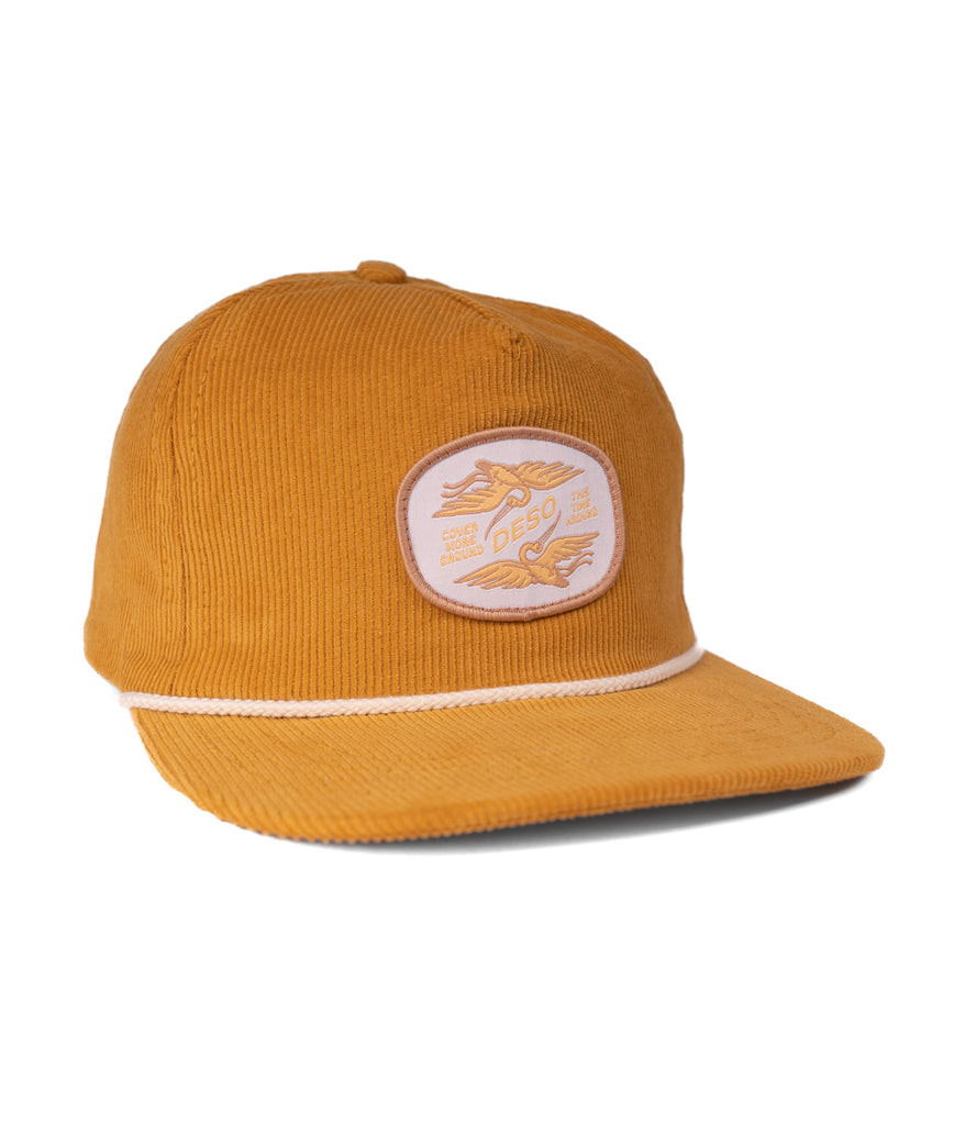 A front view of the Ibis 5 Panel Cap in gold color by Deso Supply Co.